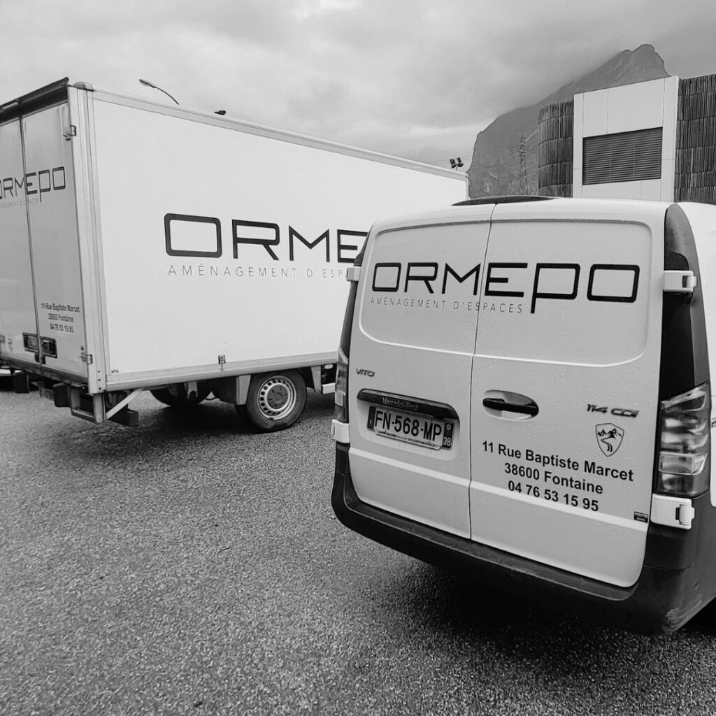 Une photo présentant l'arrière des véhicules de livraison de la société ORMEPO, avec un flocage de l'adresse, téléphone, mail de contact et logo.